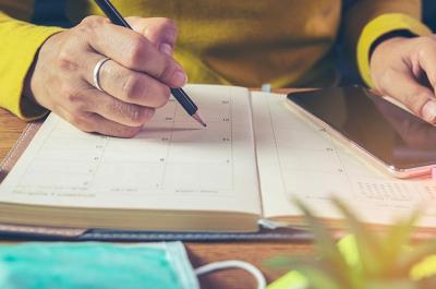 woman-yellow-shirt-writing-calendar